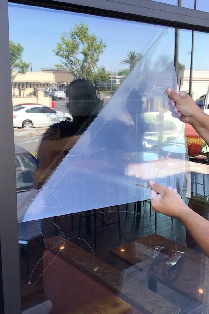 person applying window film